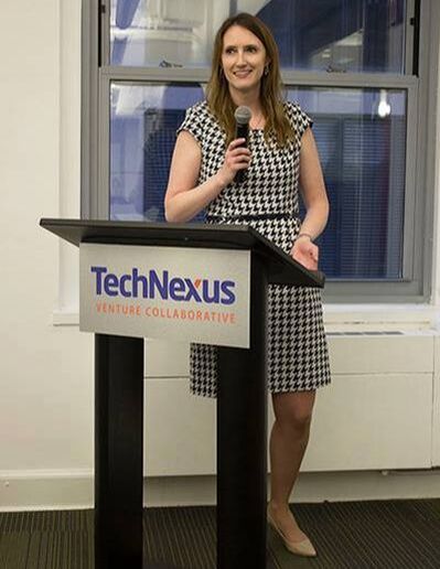 Audrey Schroder speaking into a microphone at a Social Media Club Chicago event held at TechNexus